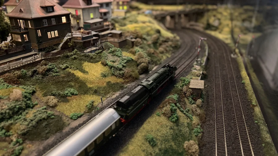 A passenger train passing landscaped hills