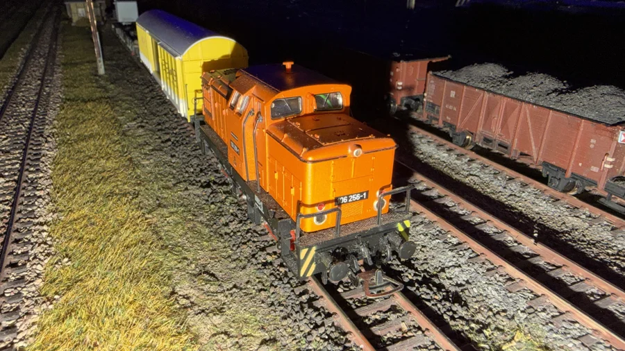 Orange maintenance locomotive with freight wagons
